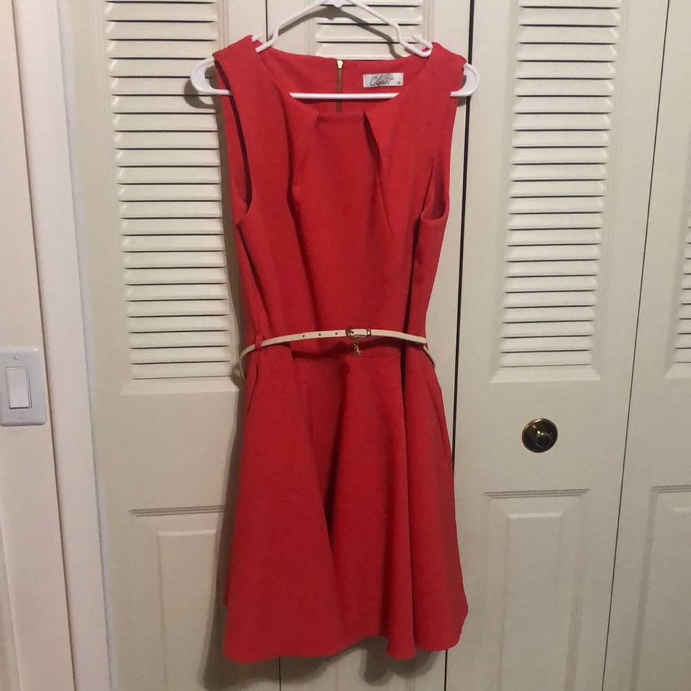 Sleeveless, coral colored, knee length dress.
